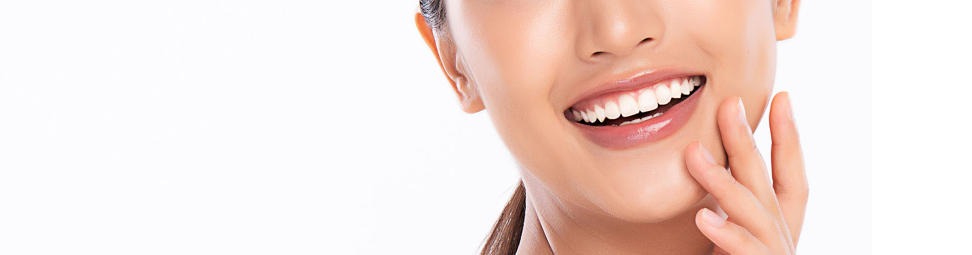 The image is a photograph of a woman with light skin, smiling at the camera. She appears to be in her late twenties or early thirties and has long hair. Her eyes are looking directly at the camera, and she is holding up her index finger near her mouth as if she s making a point or emphasizing something. The background is plain and light-colored, which suggests that this could be a stock photo used for various purposes such as advertising, personal branding, or lifestyle content.