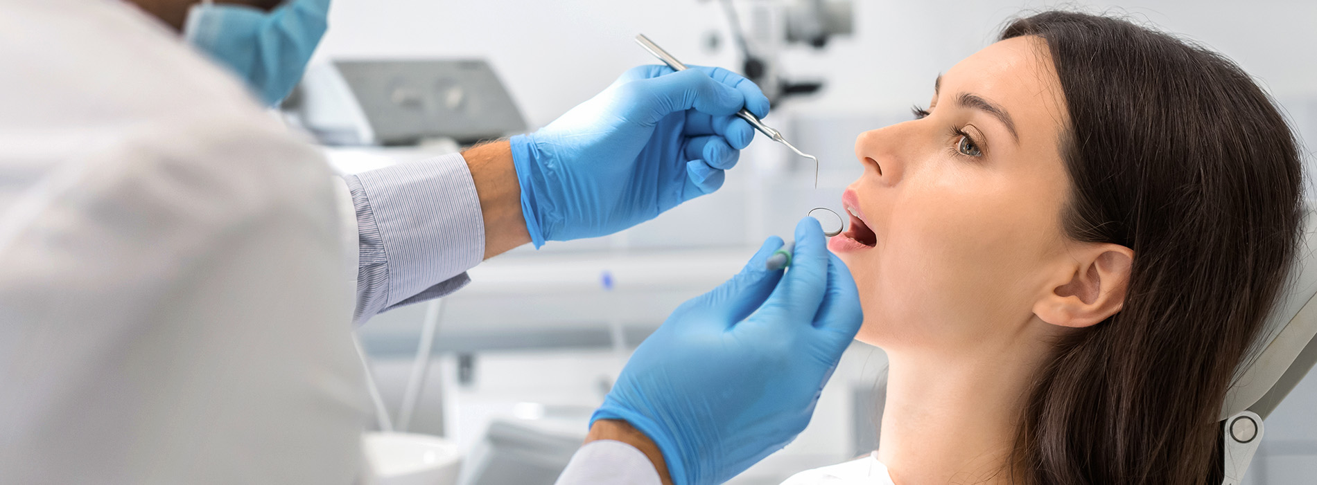 A well-lit reception area with a desk, computer monitor, and potted plant.