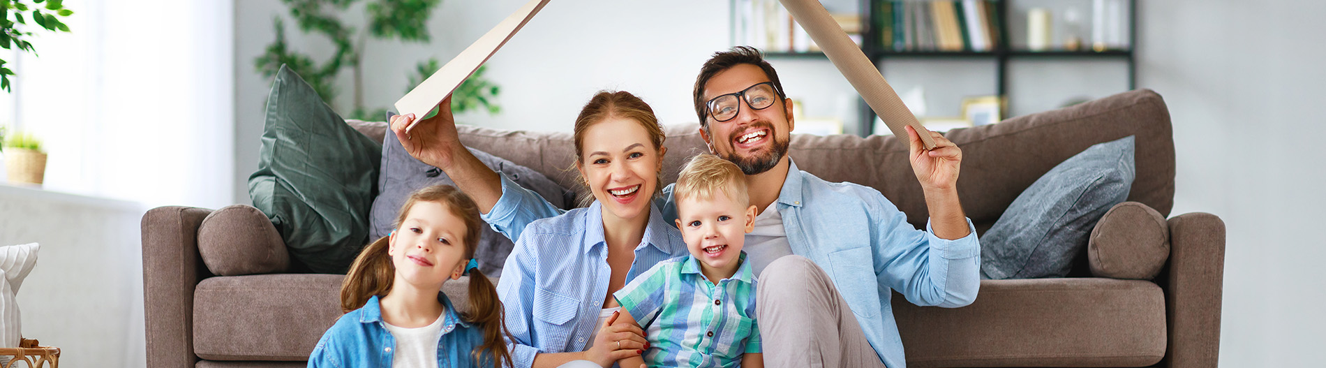 The image shows a group of people, possibly professionals given their attire and the setting that appears to be an office or professional environment. They are gathered around a table with a laptop on it, engaged in what seems to be a discussion or meeting.